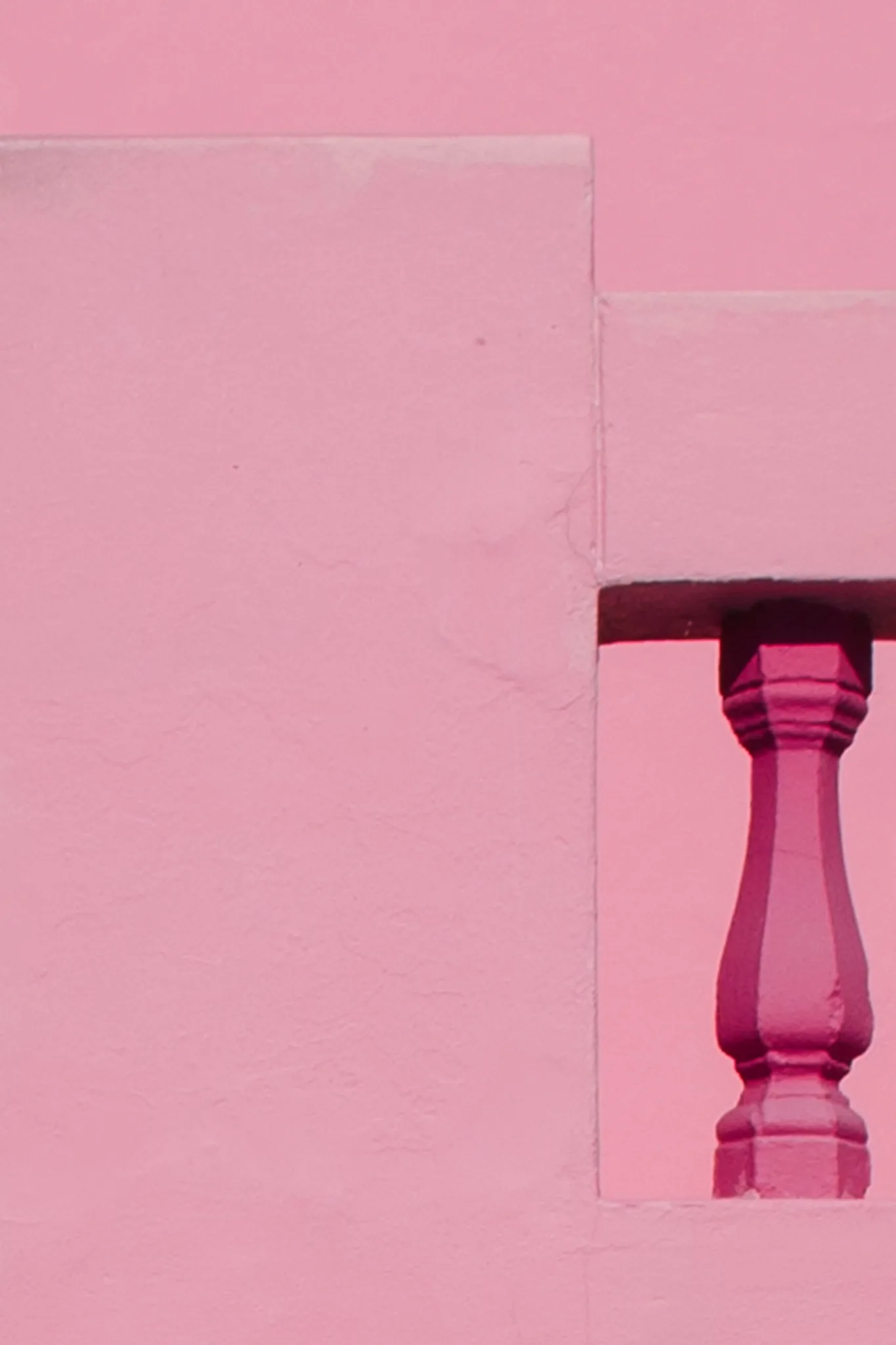 Colonna rosa incorniciata da superfici geometriche dello stesso colore Colonna rosa incorniciata da superfici geometriche dello stesso colore