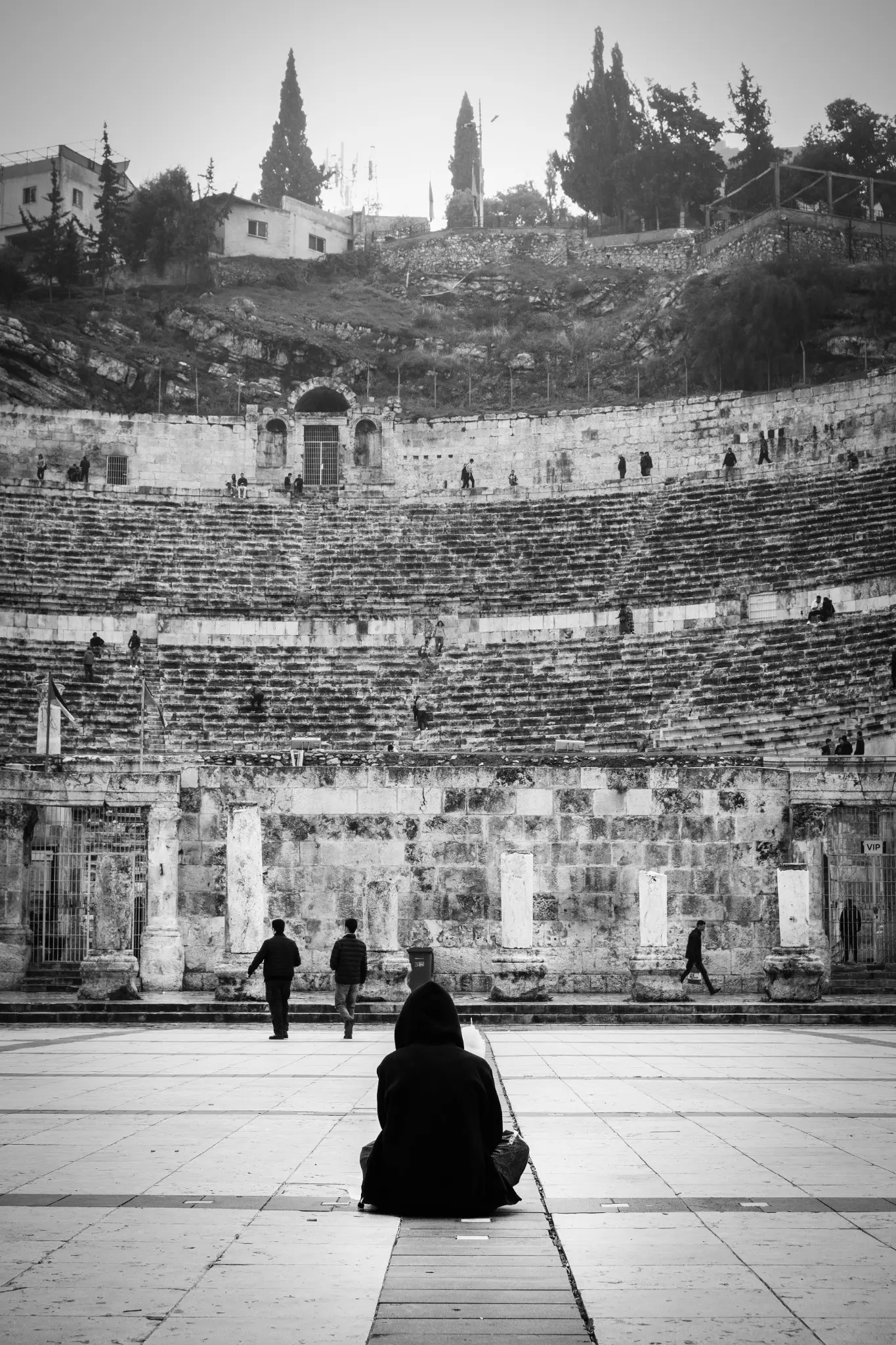 Il teatro romano di Amman attraversato da piccole figure sulle gradinate.