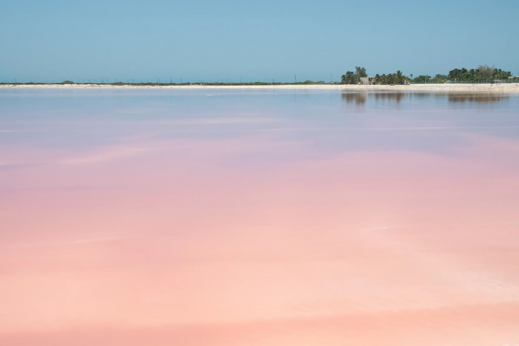 Laguna rosa dal colore tenue sotto un cielo limpido