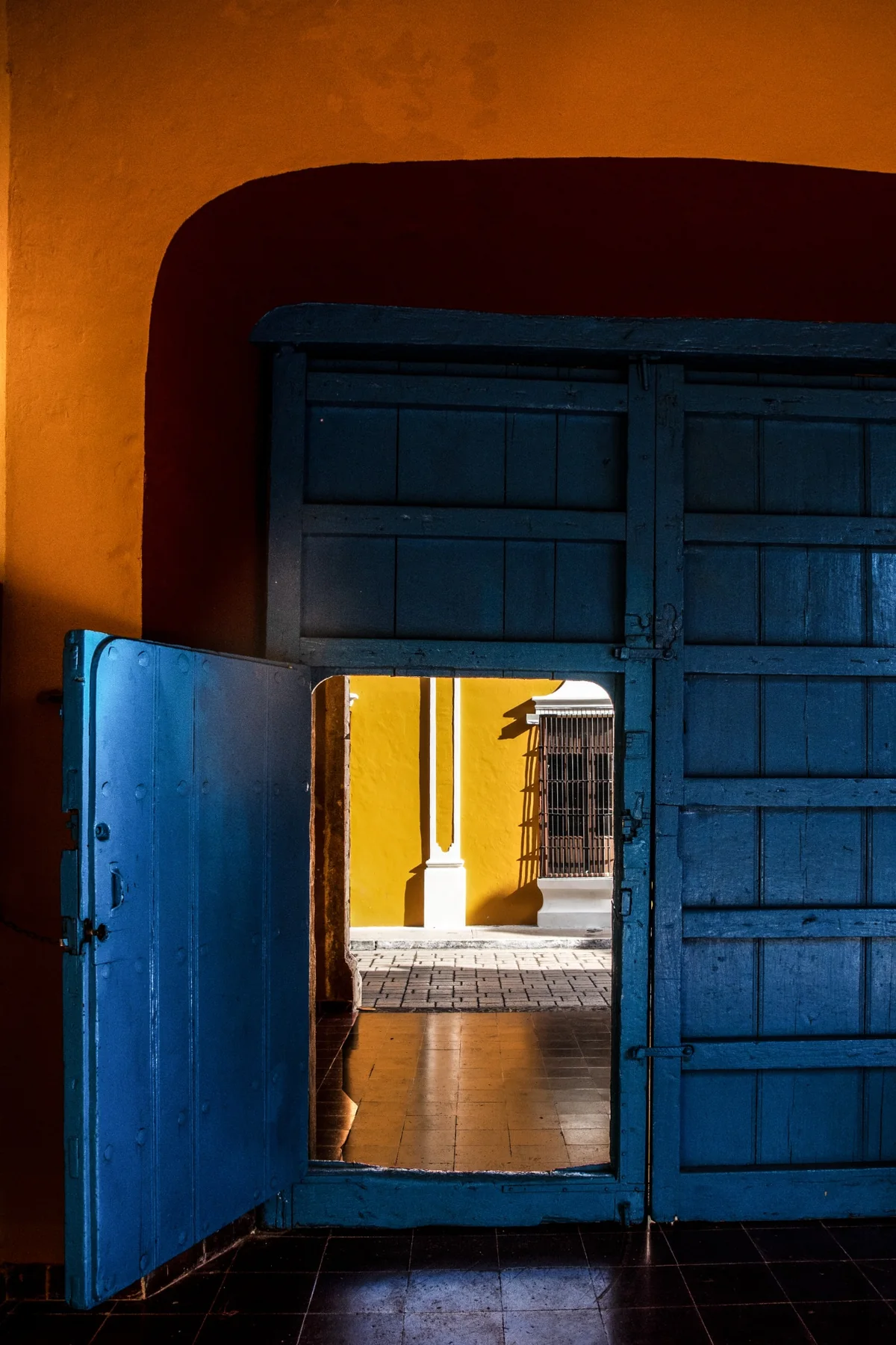 Porta azzurra socchiusa con luce calda che filtra all'interno