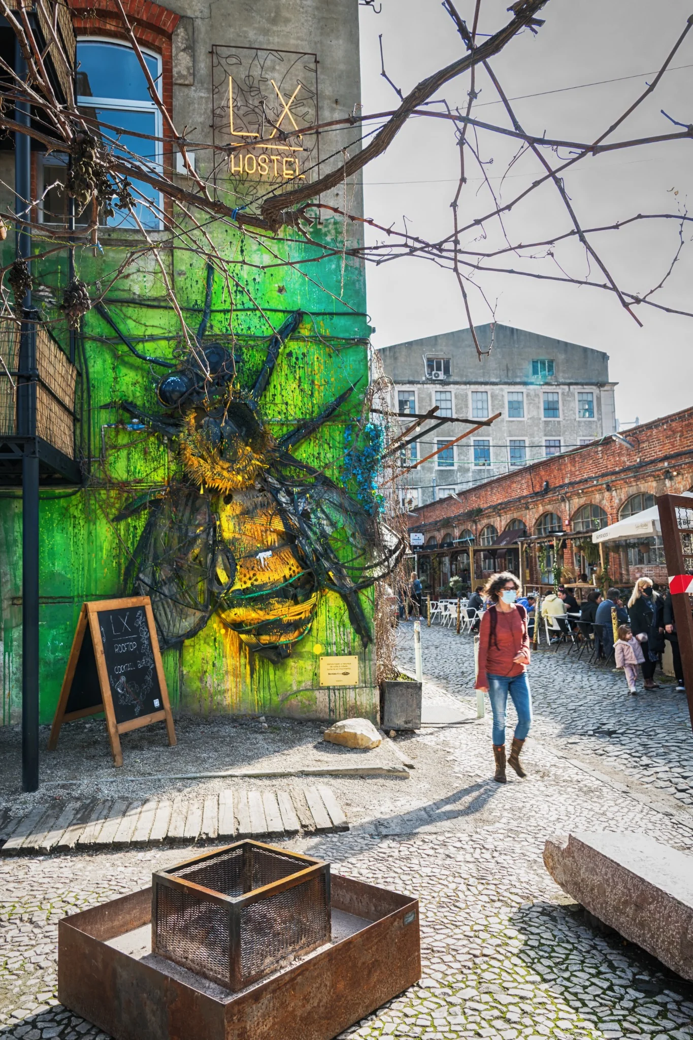 Arte urbana, passanti e colore si incontrano in una strada di Lisbona.