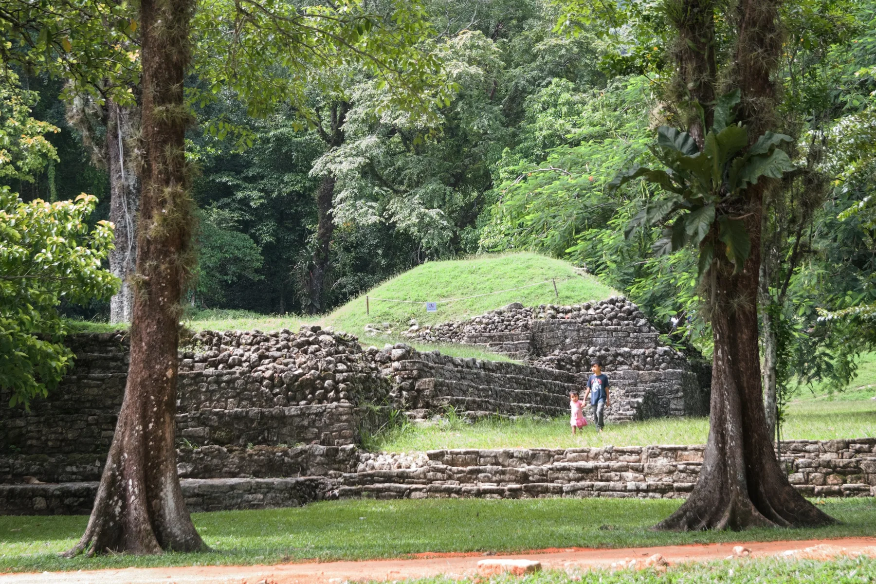 Rovine immerse nel verde con due bambini che passeggiano