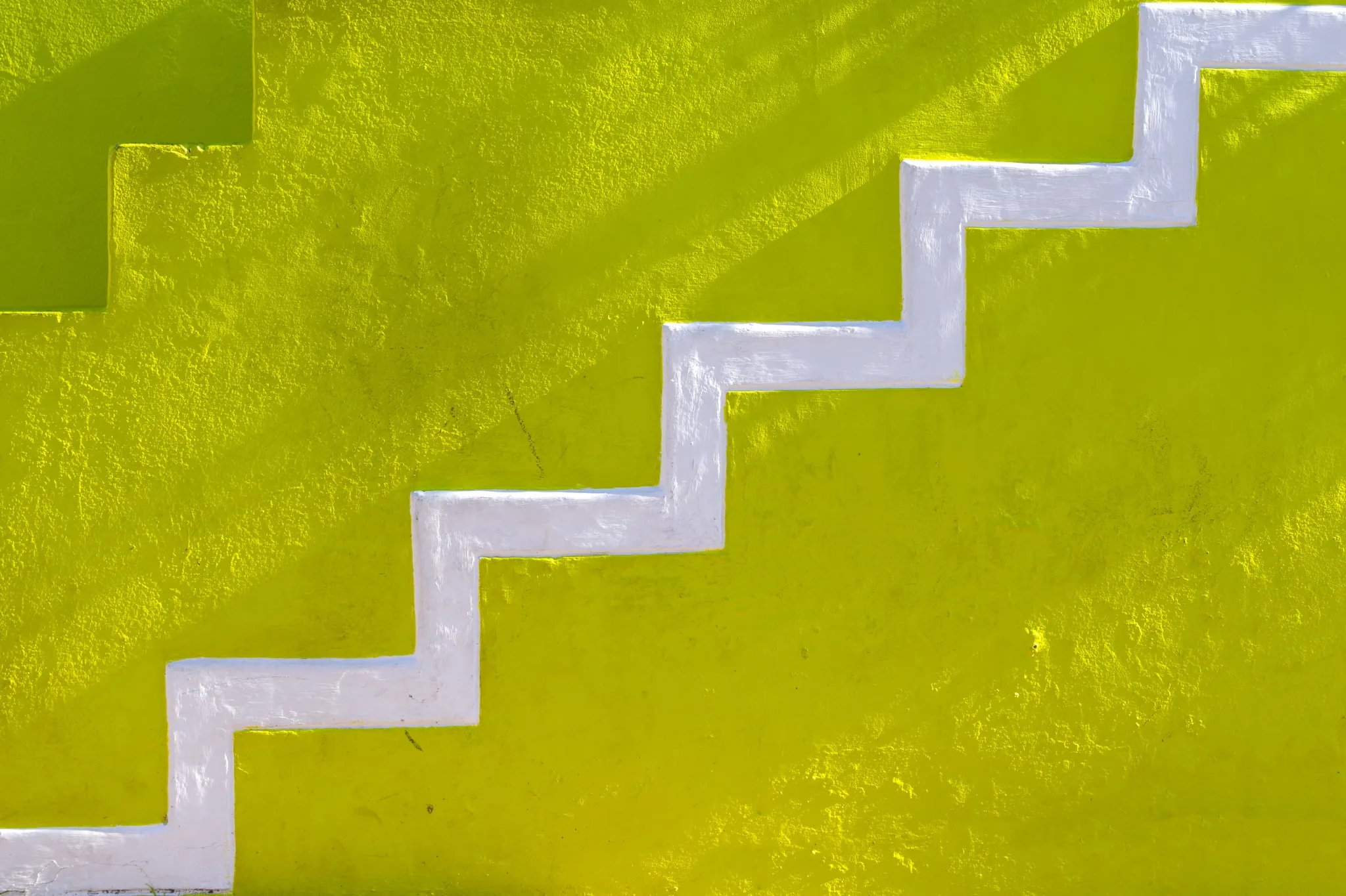 Scala bianca geometrica su un muro giallo acceso a Bo-Kaap