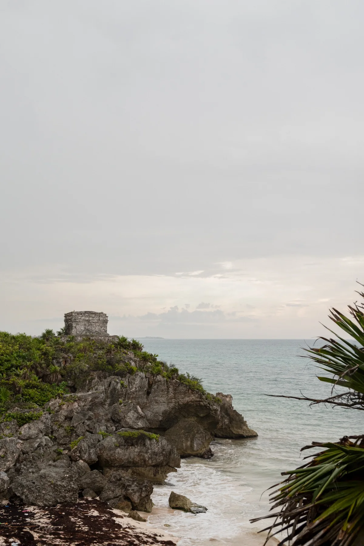 Scogliera di Tulum con il mare e un tempio in lontananza