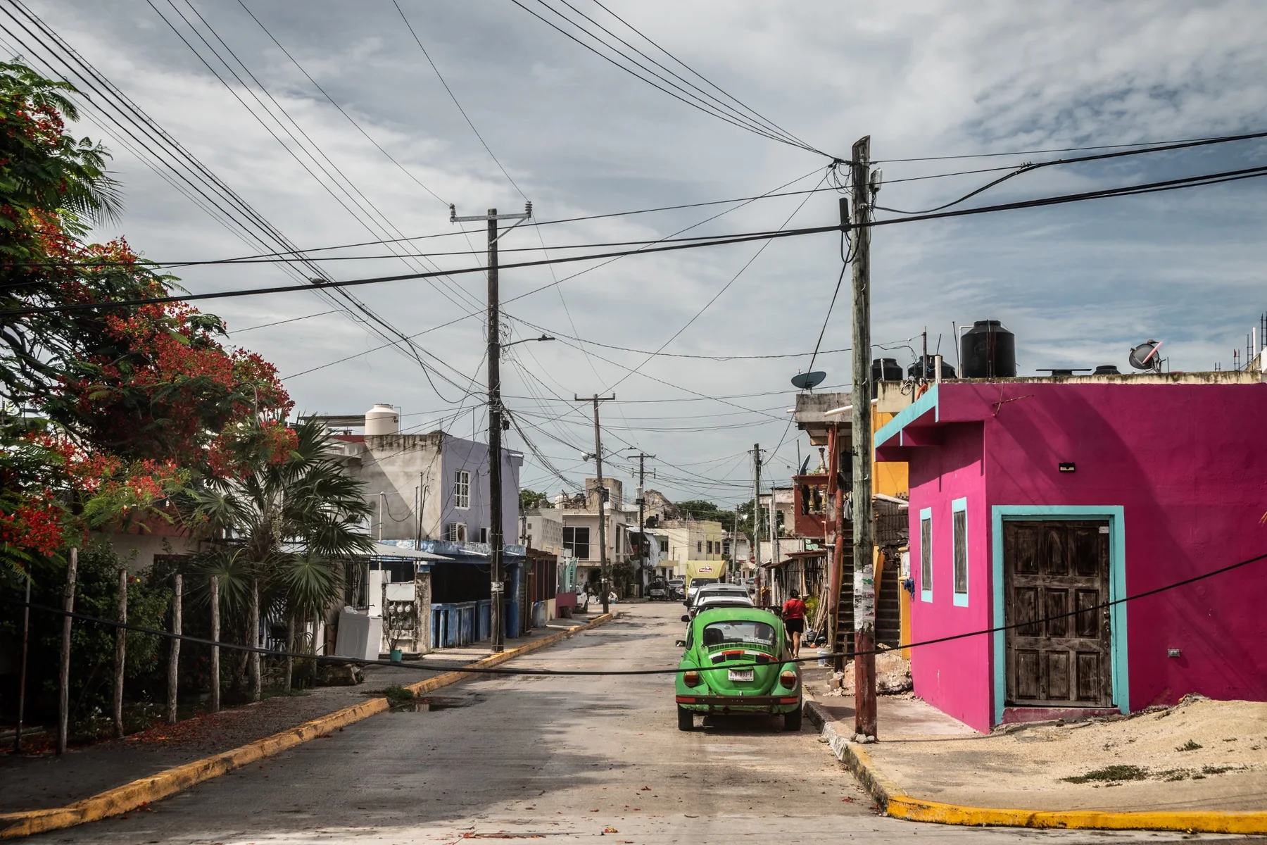 Strada in Messico con casa fucsia e maggiolino verde